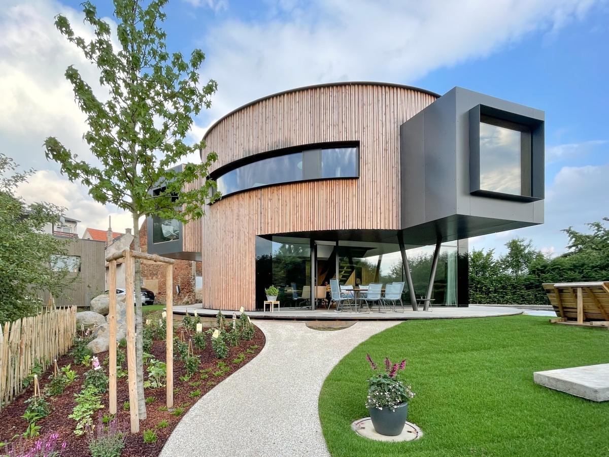 rundes Drehhaus mit Holzfassade und großen Fenstern, Gartensicht